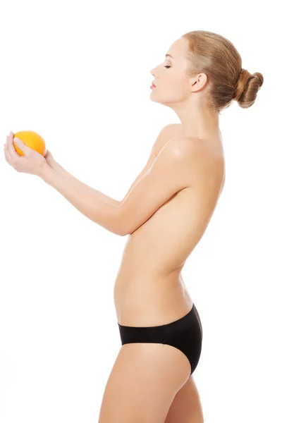 Vackra kvinnliga skinkor med orange. — Stockfoto