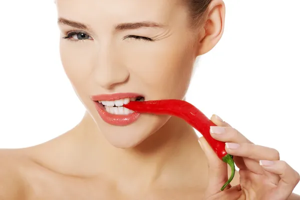 Beautiful woman with chili pepper in mouth. — Stock Photo, Image