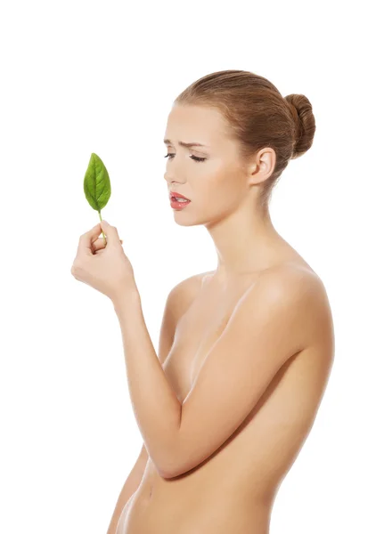 Hermosa mujer con una hoja verde . — Foto de Stock