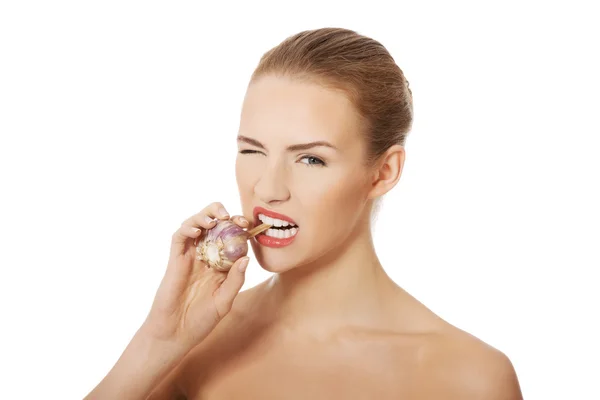 Beautiful woman with raw garlic in mouth. — Stock Photo, Image