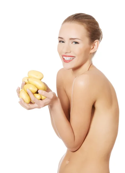 Mulher bonita segurando batatas cruas . — Fotografia de Stock