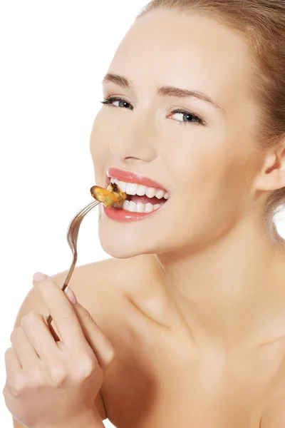 Uśmiechnięta kobieta jedzenie owoców morza z widelcem. — Zdjęcie stockowe