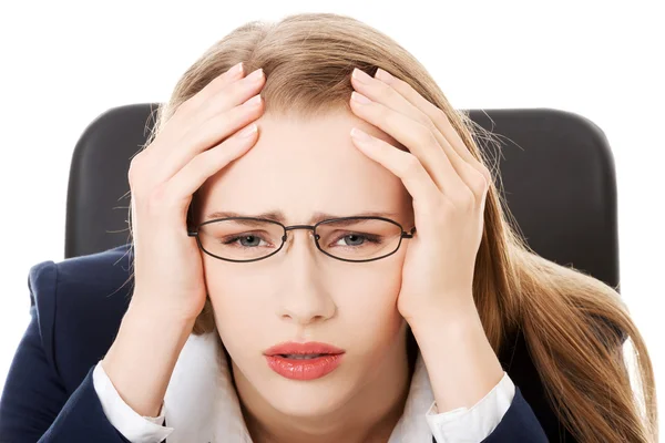 Mujer de negocios preocupada y triste sentada junto a la mesa . —  Fotos de Stock