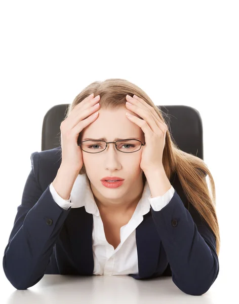 Worried, sad business woman sitting by the table. Royalty Free Stock Photos