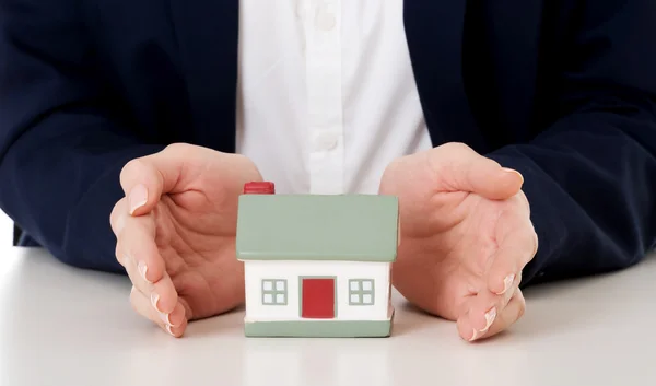 House model between hands on table. Stock Photo