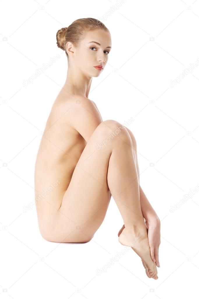 Beautiful naked caucasian woman sitting.