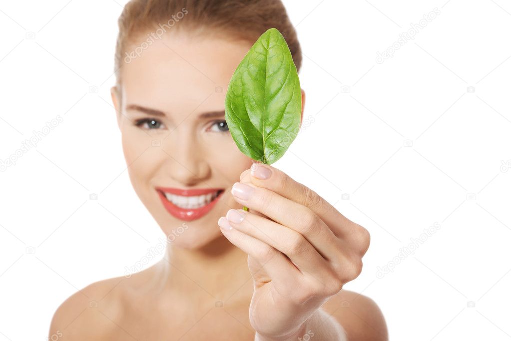Beautiful woman with one green leaf.