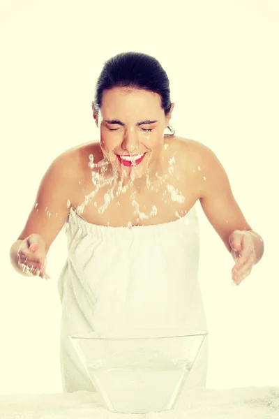 Mujer joven lavándose la cara con agua clara — Foto de Stock