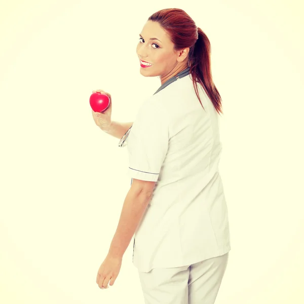 Female doctor with stethoscope holding heart. — Stock Photo, Image