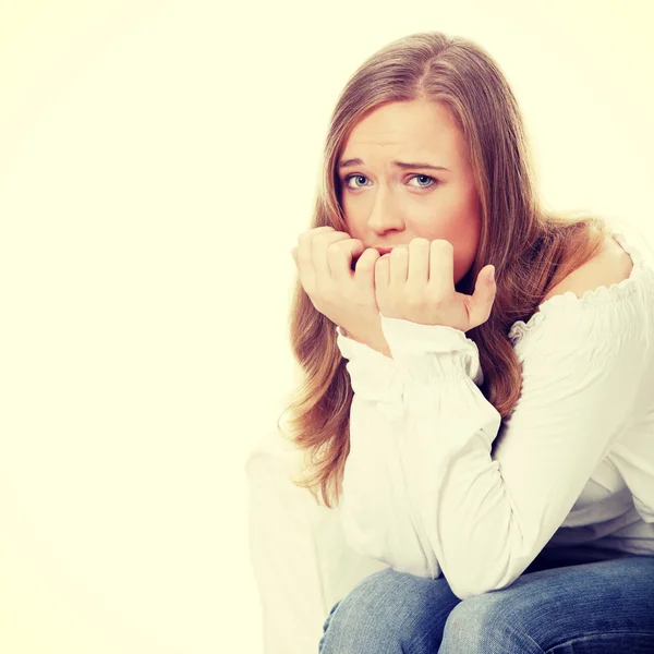 Stressed young woman eating her nails — Stock Photo, Image