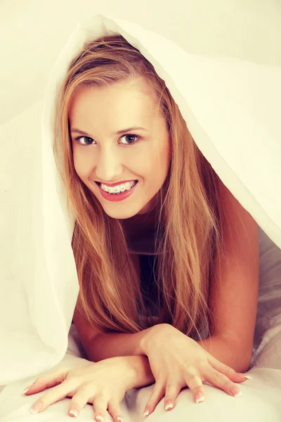 Beautiful young happy caucasian woman in bed — Stock Photo, Image