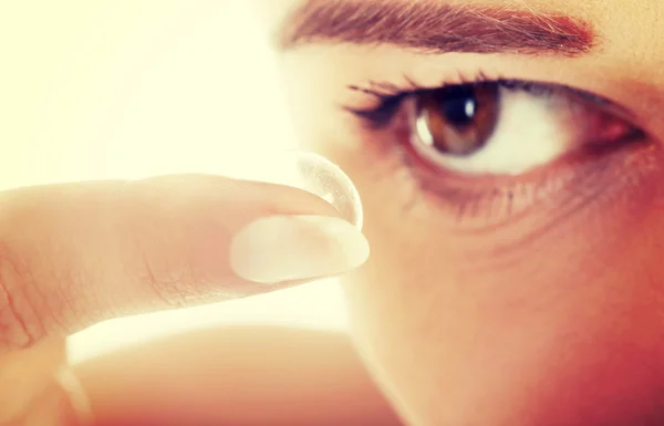 Mujer poniendo lente de contacto en su ojo —  Fotos de Stock