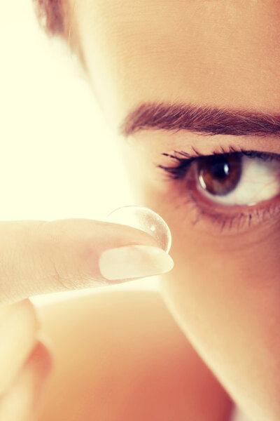 Woman putting contact lens in her eye
