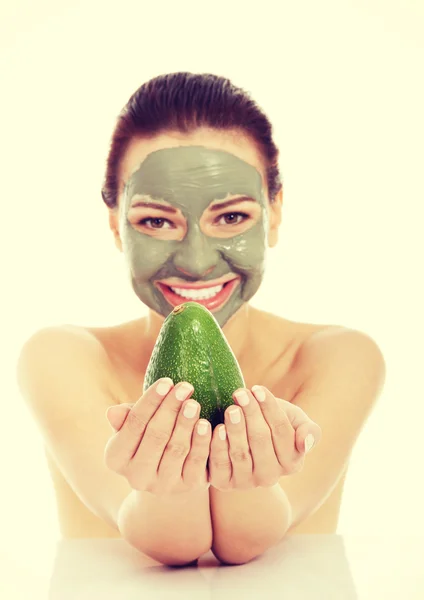 Spa vrouw in gezichtsmasker en avocado — Stockfoto