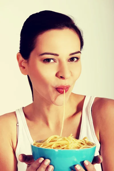 Mulher comendo massa de uma tigela . — Fotografia de Stock