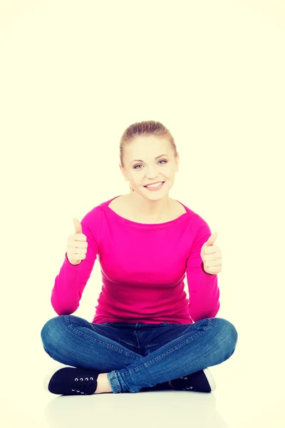 Young casual woman student showin OK gesture. — Stock Photo, Image