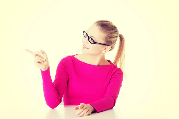 Young casual woman pointing aside. — Stock Photo, Image