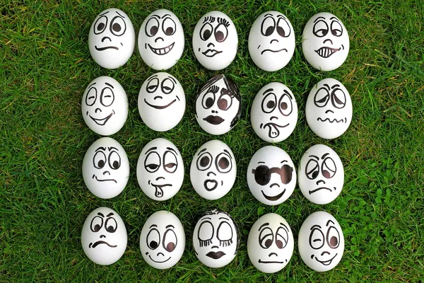 Huevos blancos y muchas caras divertidas — Foto de Stock