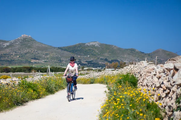 Mulher está pedalando na Ilha Favignana — Fotografia de Stock