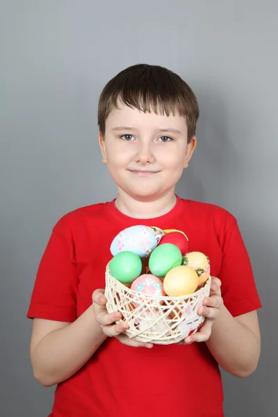 Menino com uma cesta de ovos de Páscoa — Fotografia de Stock