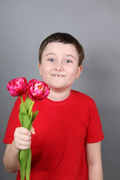 男孩用一束红色的郁金香 — 图库照片