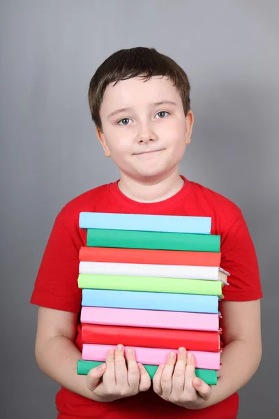 Garçon avec une pile de livres — Photo