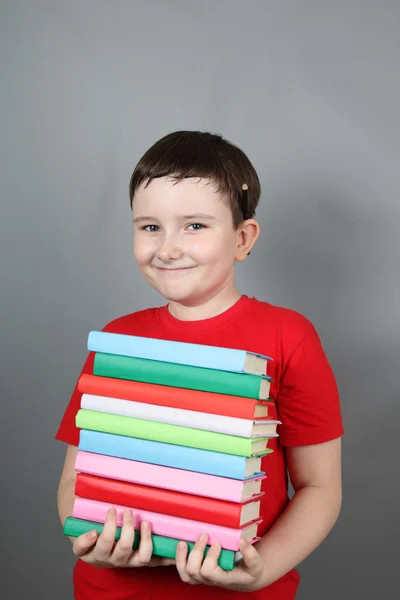 Rapaz com uma pilha de livros — Fotografia de Stock