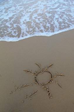 güneş kum üzerine çizilmiş