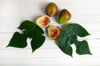 Hafif ahşap arka planda yaprakları olan incirler..