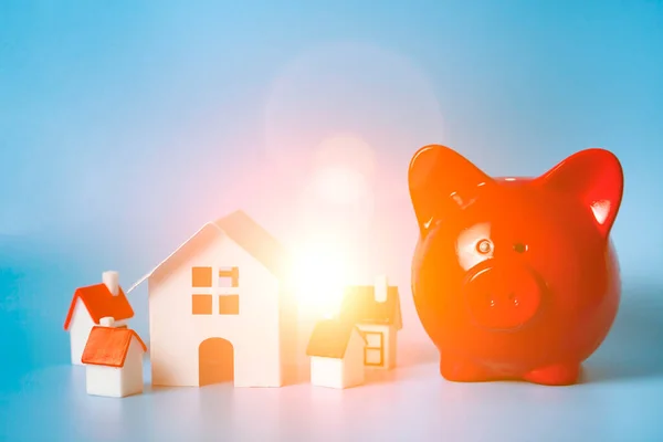 猪猪仔银行和蓝色背景的小房子房地产采购概念 — 图库照片