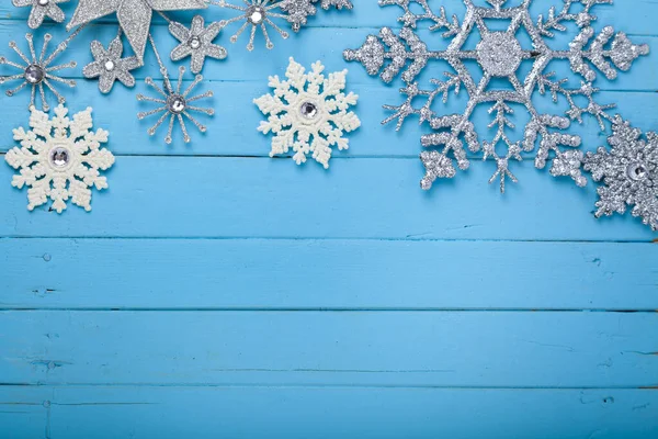 青い木製の背景に白と銀のクリスマスの雪片 クリスマスカード テキストの場所 — ストック写真