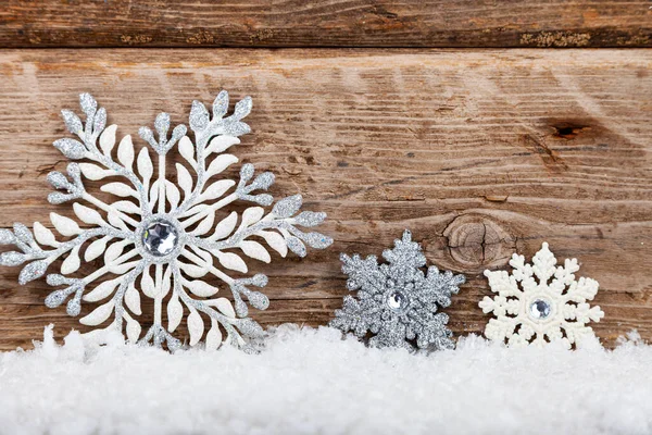 银白色的圣诞雪花在木制背景的雪地上飘扬 圣诞卡放在你的文字位置上 — 图库照片