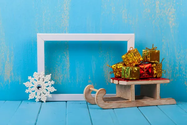 Nieuwjaarsgeschenken Een Slee Een Frame Een Blauwe Achtergrond Kerstkaart — Stockfoto