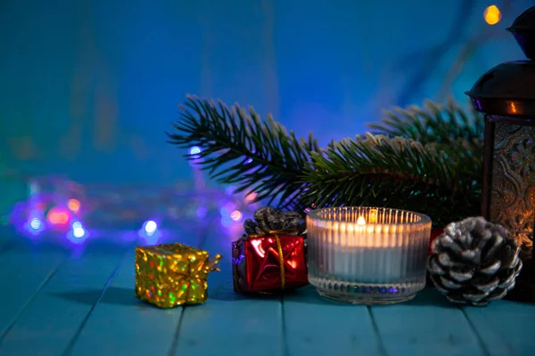 圣诞灯火背景下的蜡烛 装饰和圣诞树 节日明信片 — 图库照片