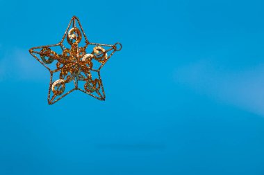 Mavi arka planda altın yıldız. Uçan Noel dekoru. Metnin için yer.
