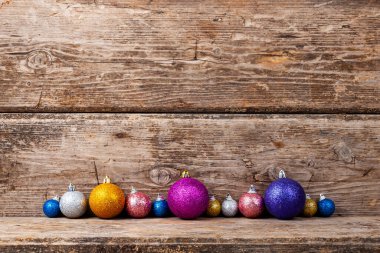 Ahşap arka plandaki çok renkli taşakların sınırı. Noel şenliği arka planı.