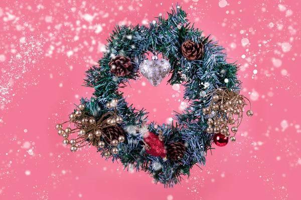 Pembe arka planda kalbi olan bir Noel çelengi. Noel dekoru.