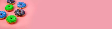 Pembe arka planda çok renkli donutlar. Pankart. Metnin için yer.