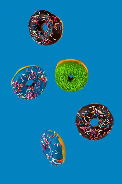 蓝色背景上的五颜六色的甜甜圈 — 图库照片