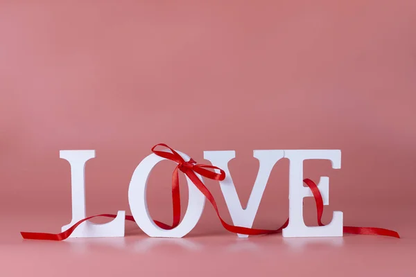 Word Liefde Met Rood Lint Strik Een Roze Achtergrond Valentijnskaart — Stockfoto