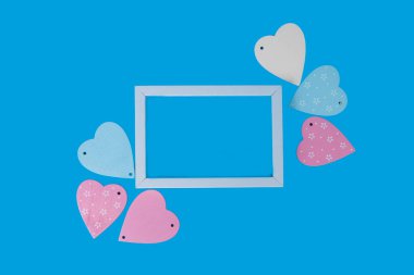 Hearts and white frame on a blue background. Valentine's Day.