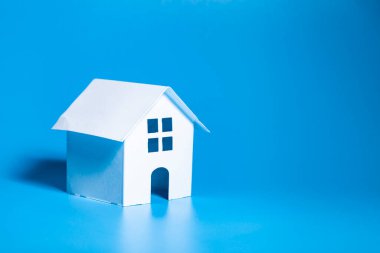 Rent apartments, Real Estate and buying a house idea. Toy house on a blue background.