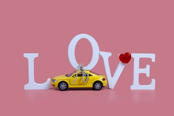Yellow Car Carries Word Love Pink Background Valentine Day — Fotografia de Stock