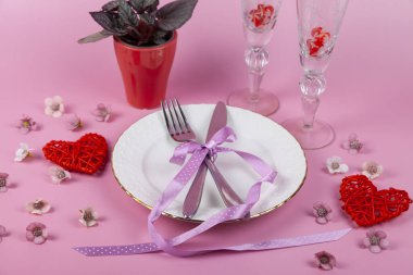 Sevgililer Günü 'nde pembe arka planda kırmızı kalplerle romantik bir yemek. Boşluğu kopyala.