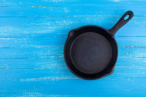 Lege Gietijzeren Pan Een Blauwe Houten Ondergrond Plaats Voor Tekst — Stockfoto