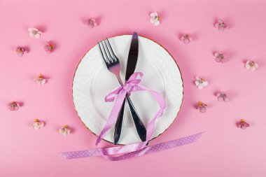 Çatal bıçak ve çatal takımı, beyaz tatlı tabağı, pembe arka plan, üst manzara, telif alanı