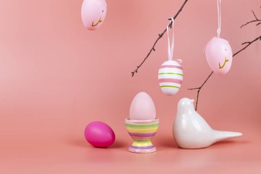 Dalda paskalya yumurtaları, pembe arka planda bir kuş. Metin için yer.