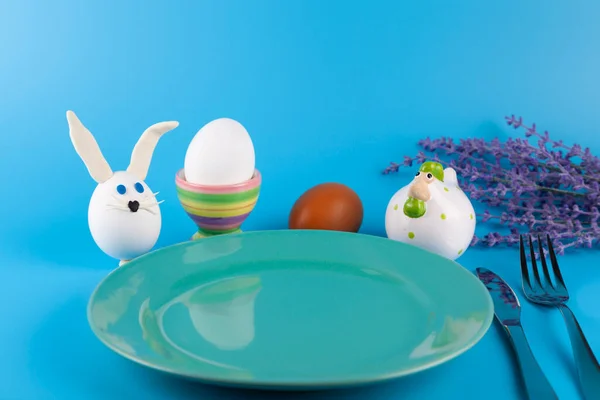 イースターテーブルの設定とお祝いの装飾 ひよこや多色の卵と夕食 青の背景 閉じろ — ストック写真