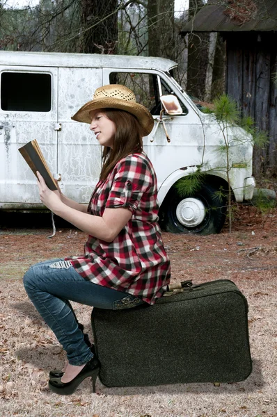 Жінка читає на валізі — стокове фото