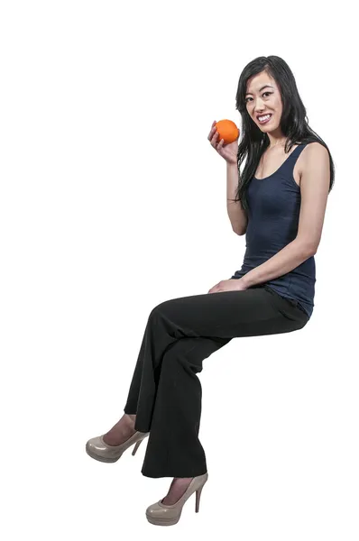 Женщина сидит на апельсине — стоковое фото